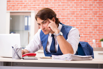 Young handsome employee working in the office 