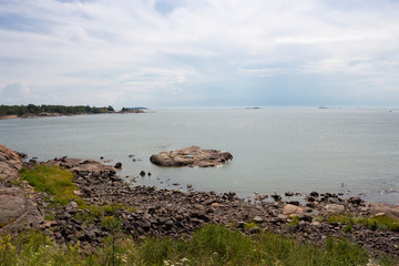 Coast, stones and view from the island of Suomenlinna to the Gulf of Finland and the islands in it on a summer day in Finland.