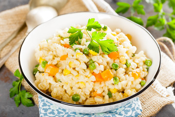 Bulgur wheat boiled with carrot, green peas and corn, healthy vegan diet