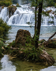 natural waterfalls in Plitvice Lakes National Park; beautiful natural landscape with lake and waterfalls; all around the forests, the lake water is bluish-green