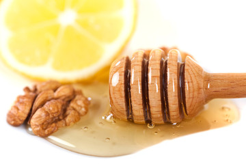 honey dipper, walnut and lemon on a white background