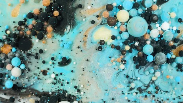 Colorful paint in bubbles organically moves in the liquid