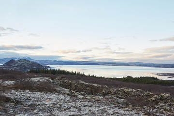 Thingvallavatn lake with reflection of sun during winter near sunrise