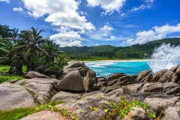 water fountain over granite rocks,wild tropical beach with palms, seychelles 1
