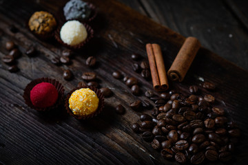 Coffee beans on wooden background with cinnamon stick and chocolates