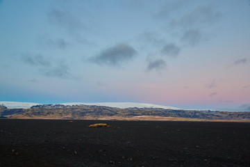 Fototapeta na wymiar Icelandic Sunset over mountain black stones in foreground