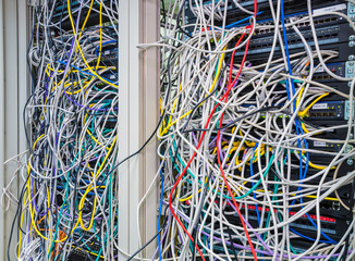 Switchboard panel with chaotic mess  cables connections, Chaos In Server Room, The tangled network...