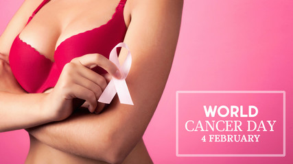 World cancer day concept background. Young woman examining her breast for lumps or signs of breast cancer. Pink Ribbon.