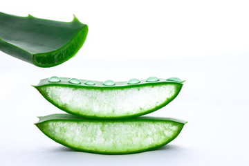 Aloe Vera in Stücke und Tropfen vor weißem Hintergrund