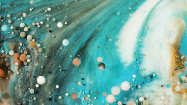 Colorful paint in bubbles organically moves in the liquid