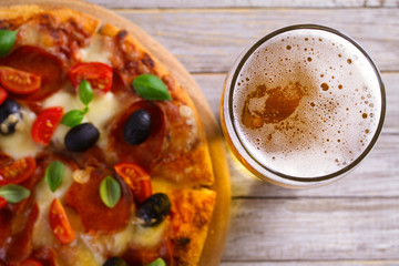 Beer and pizza on wooden plate. Ale and  snack. Overhead, horizontal