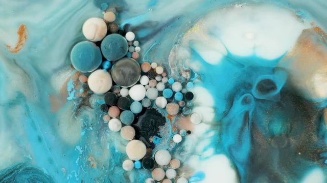 Colorful paint in bubbles organically moves in the liquid