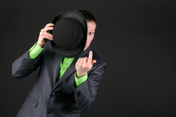 Man is looking out from a bowler hat in one hand and is calling for someone by another hand and...