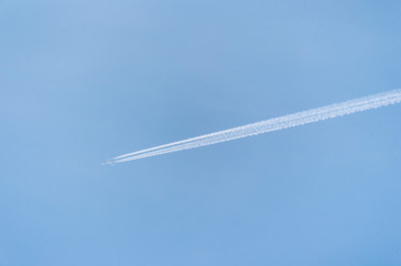 The liner flies in the blue sky and leaves a trace