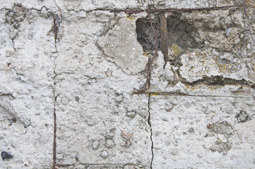 Background and texture of concrete with cracks and damage. Visible rusty iron wire.