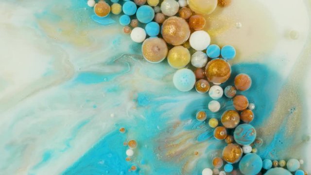 Colorful paint in bubbles organically moves in the liquid