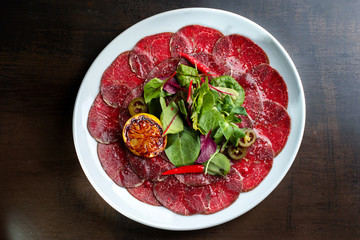 Beef carpaccio with lemon, hot red pepper and pepper jalapeno.