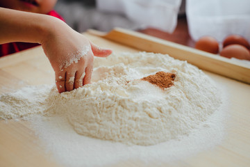 Help children during baking and cooking. The child helps to prepare the dough for baking. Baking cookies, family baking together. Flooding, making cookies. The concept of cooking.