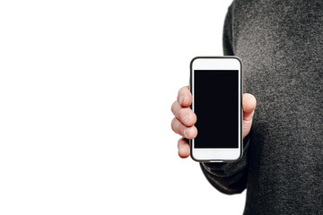 White telephone with empty, blank screen in the hand. The man shows a phone with a black display, ready to be filled with content. The concept of entering information on the phone. Using a smartphone.