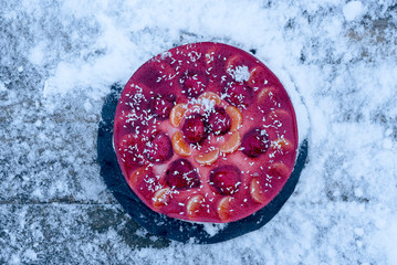 Obraz na płótnie Canvas fruit cake on a wooden snowy background
