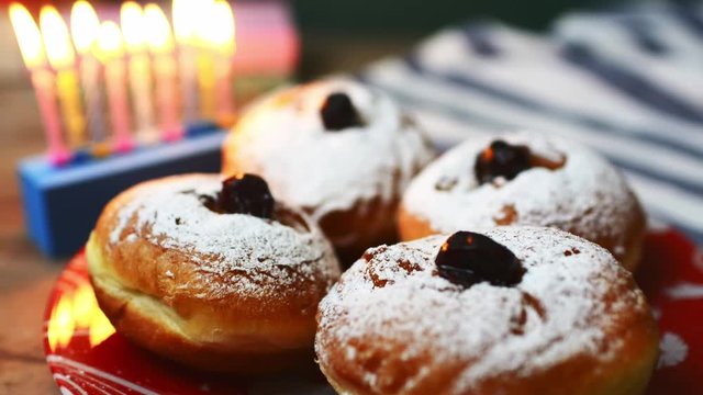 nine candles and doughnuts with sugar powder (jewish holiday Hanukkah)