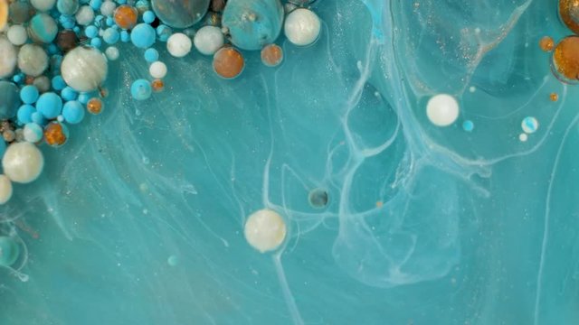 Colorful paint in bubbles organically moves in the liquid