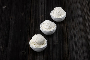 Vanilla ice cream with bowl on wooden background