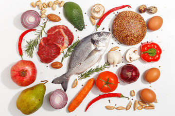 Healthy food clean eating selection: fruit, vegetable, seeds, fish, meat, leaf vegetable on white background. Top view.