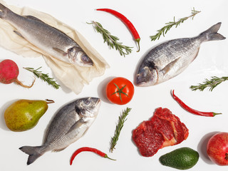 Healthy food clean eating selection: fruit, vegetable, seeds, fish, meat, leaf vegetable on white background. Top view.