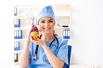 Young female doctor cardiologist sitting at the hospital 