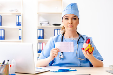 Young female doctor cardiologist sitting at the hospital 