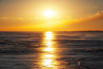 Fototapeta premium Zima krajobraz z zamarzniętym jeziorem i zmierzchu ognistym niebem. Skład natury.