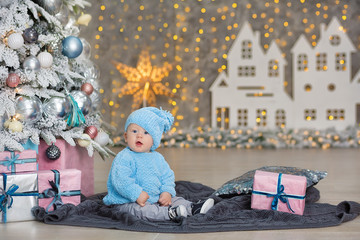 Christmas portrait of cute little newborn baby boy, dressed in christmas clothes and wearing santa hat, studio shot, winter time