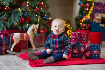 Christmas portrait of cute little newborn baby boy, dressed in christmas clothes and wearing santa hat, studio shot, winter time