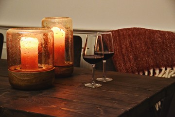 Hygge evening with glass of red wine and candles. Cozy home