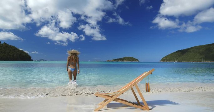 bikini straw hat woman walking into water at maho bay, st john