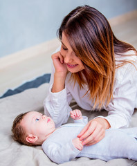 Mother and a little child lying down on bed background