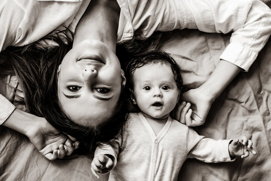 Mother and a little child lying down on bed background . Image in black and white color style