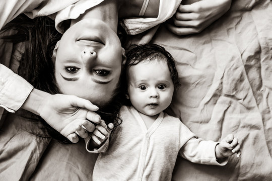 Mother and a little child lying down on bed background . Image in black and white color style