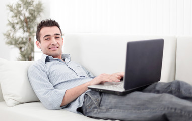 guy with laptop lying on the sofa
