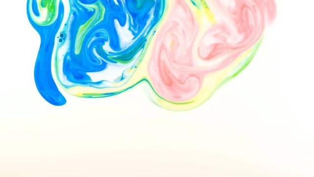 Colorful paint drops mixing in the milk. Liquid paint colorful patterns of moving surface