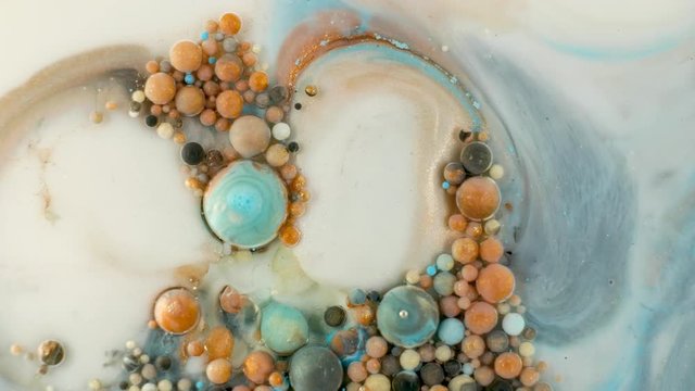 Colorful paint in bubbles organically moves in the liquid