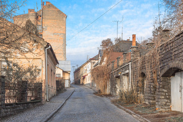 Street in the old town. Travel in Europe. Cityscape. Pavement on the street. Low-rise buildings along the road. Facade of old residential buildings. The architecture of old Europe.