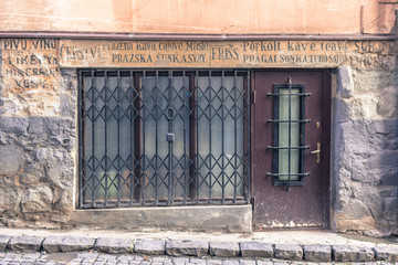 The facade of a historic building. Windows with carved frames. The original exterior of the restaurant. Old house. Travel in Europe. Walk in Ukraine. Wooden windows and doors. Vintage style.