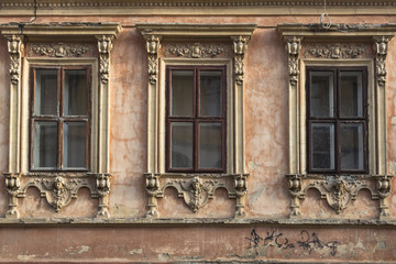Fototapeta na wymiar The facade of a historic building. Windows with carved frames. The original exterior of the restaurant. Old house. Travel in Europe. Walk in Ukraine. Wooden windows and doors. Vintage style.
