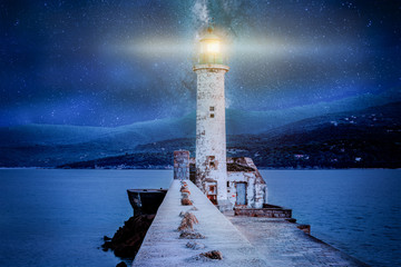 Leuchtender Leuchtturm nachts am Meer mit Sternenhimmel