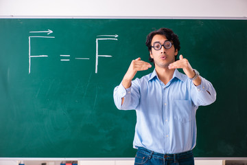 Young male physic standing in front of the green board