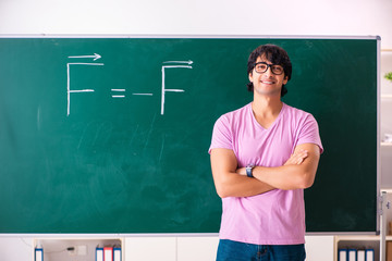 Young male physic standing in front of the green board