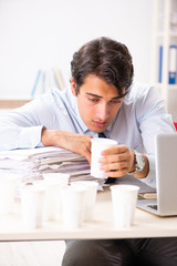 Obraz premium Young employee addicted to coffee