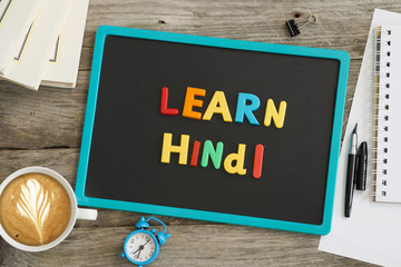 Dark chalkboard with Learn Hindi message from colourful plastic letters